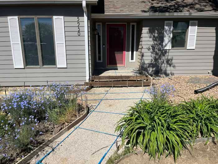 Exterior view of a house with a gravel pathway and landscaping leading to the front door.
