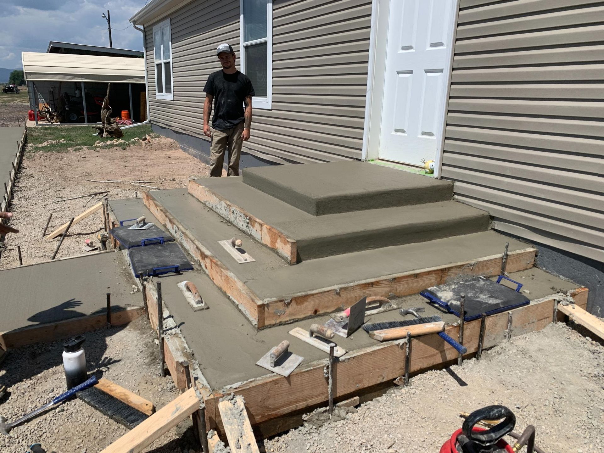 Man standing on concrete steps under construction outside a building.
