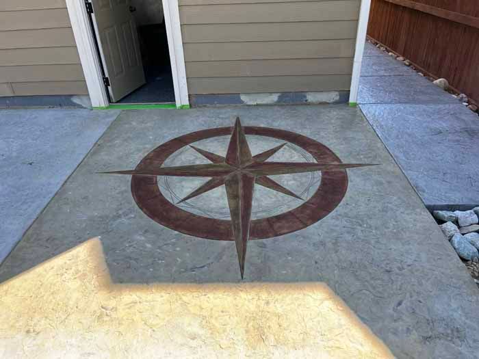Concrete patio with a red compass rose design.