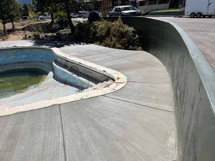 Concrete skatepark bowl with a curved wall.