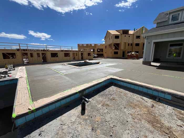 Construction site with concrete work; framing for buildings, blue sky.