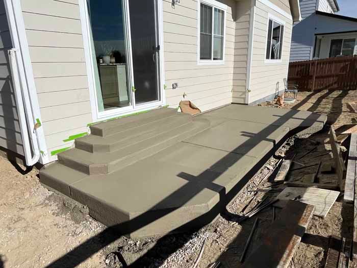 New concrete patio and steps outside a house.
