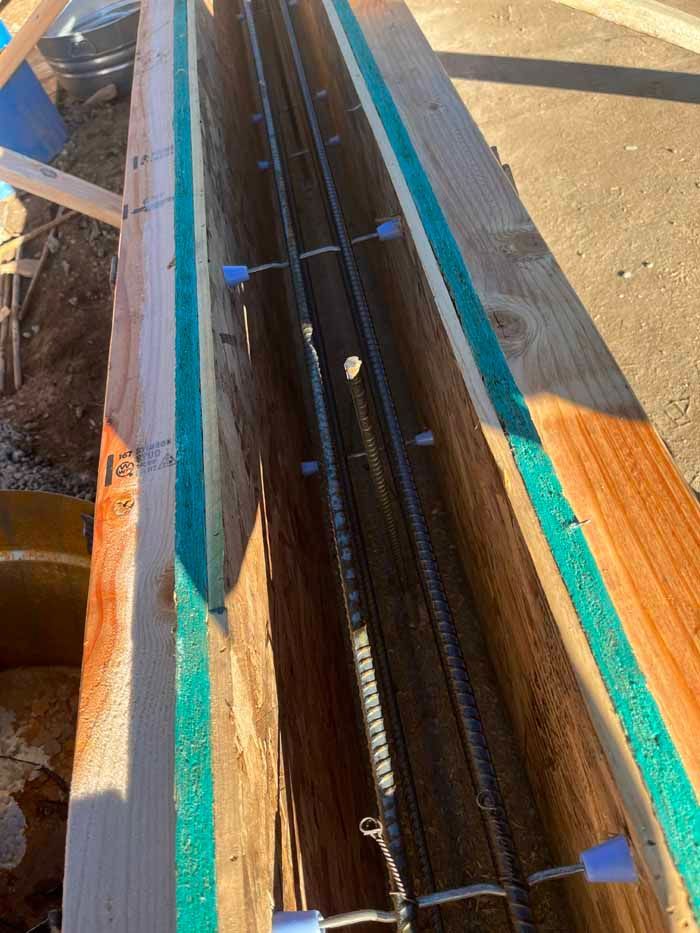 Wooden formwork with steel rebar, ready for concrete pour.