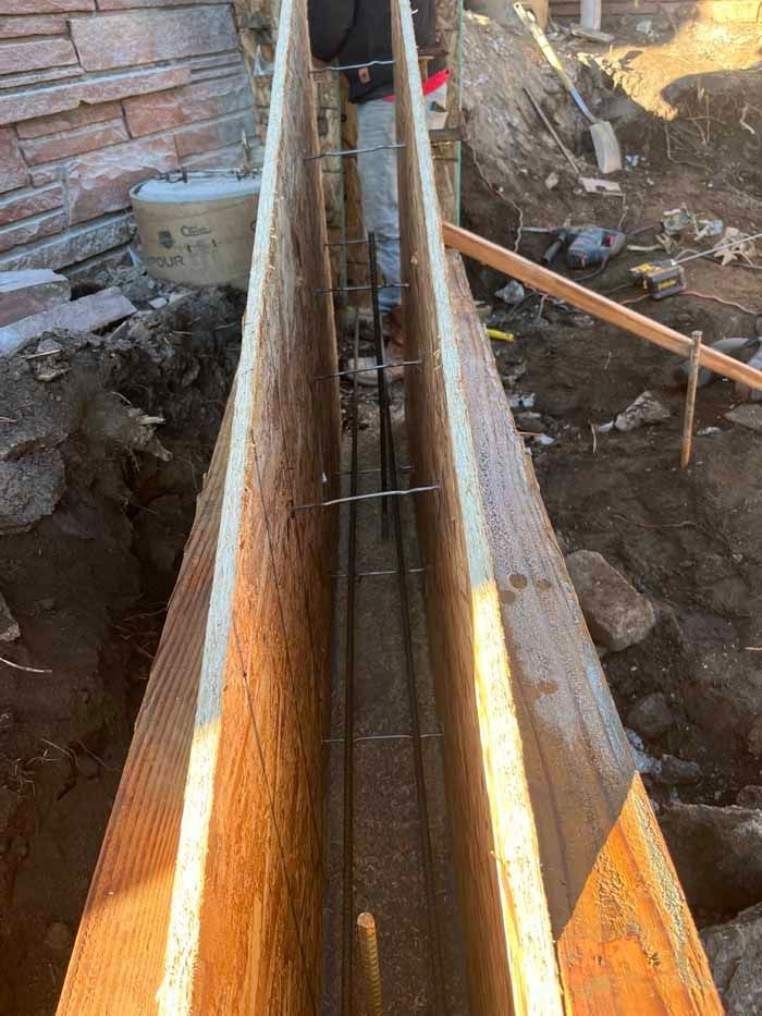 Wooden formwork for concrete foundation with rebar reinforcement. Construction site.