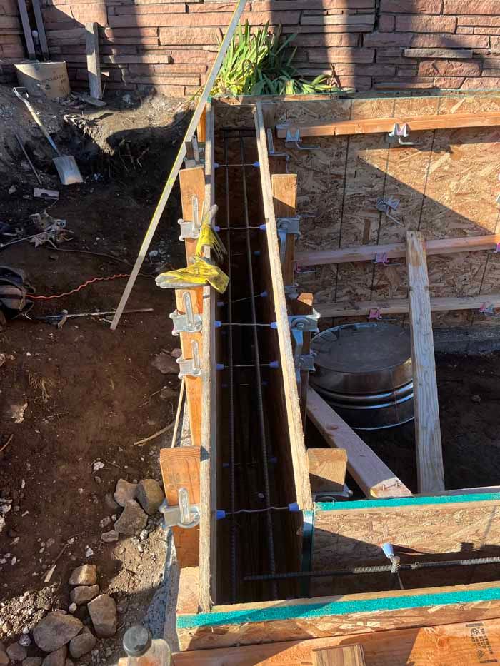 Formwork for a concrete wall, with rebar reinforcement in place. Construction site.