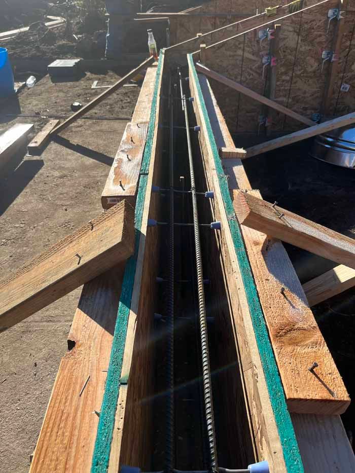 Wooden formwork with steel reinforcement for a concrete structure, outdoors.