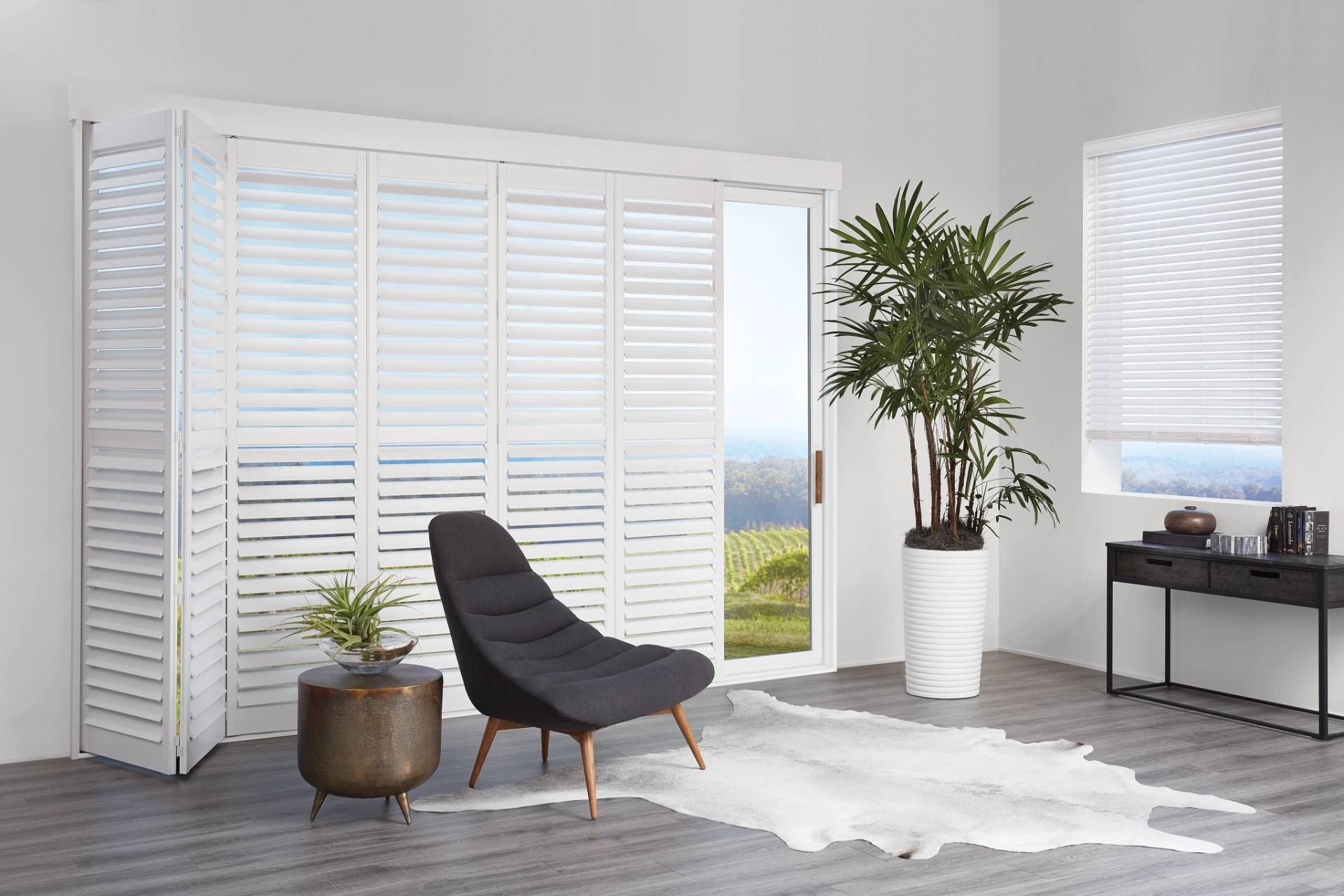 Hunter Douglas NewStyle® Composite Shutters on a sliding glass door in a sitting area 