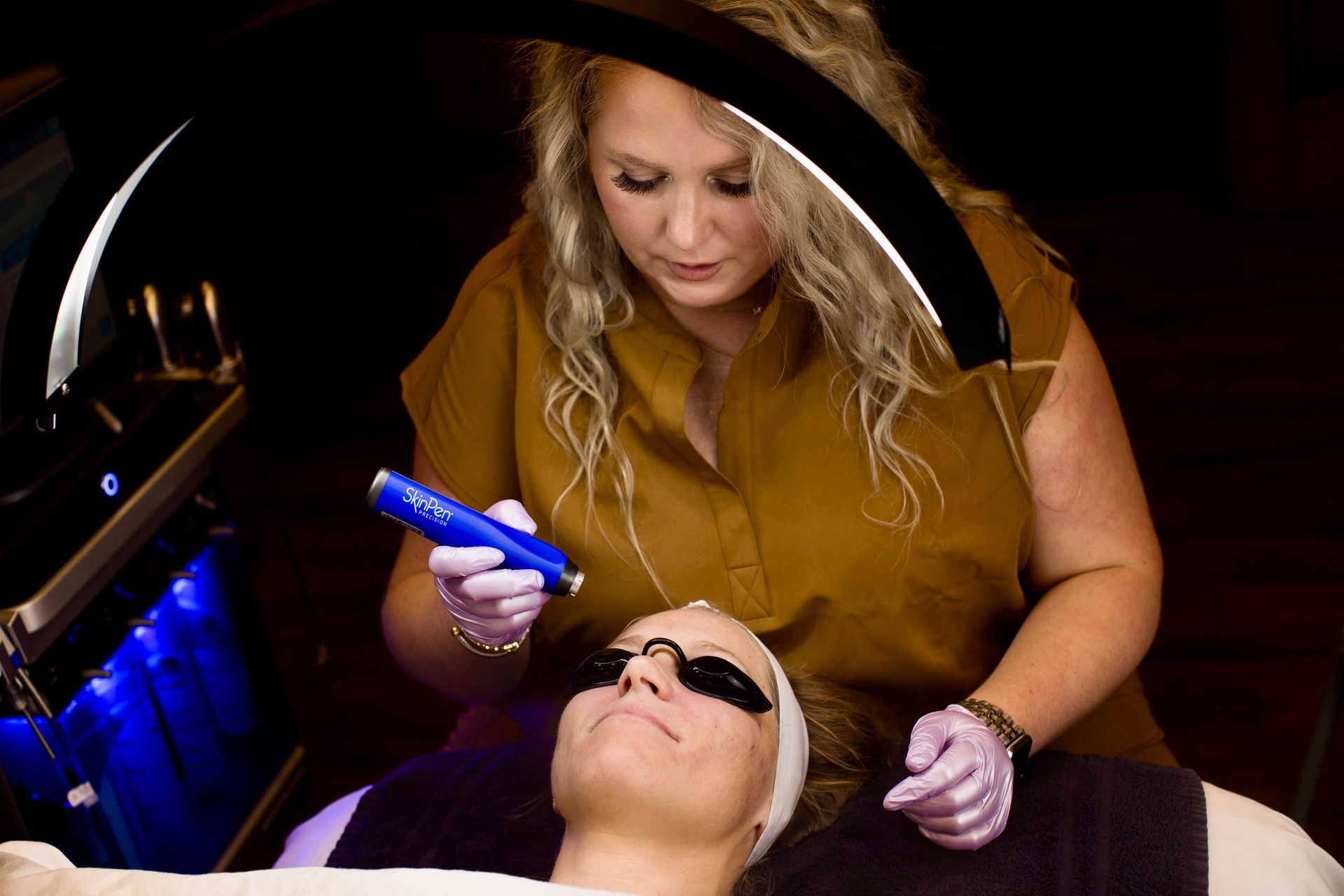 A woman is getting a laser treatment on her face.