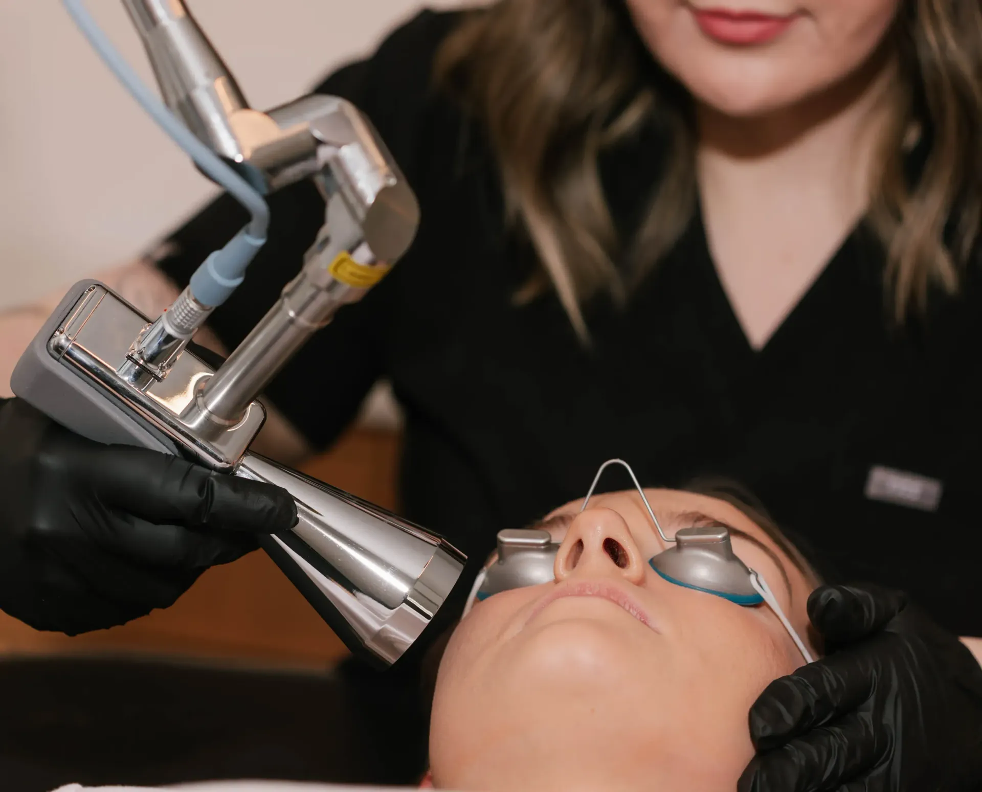 A woman is getting a laser treatment on her face