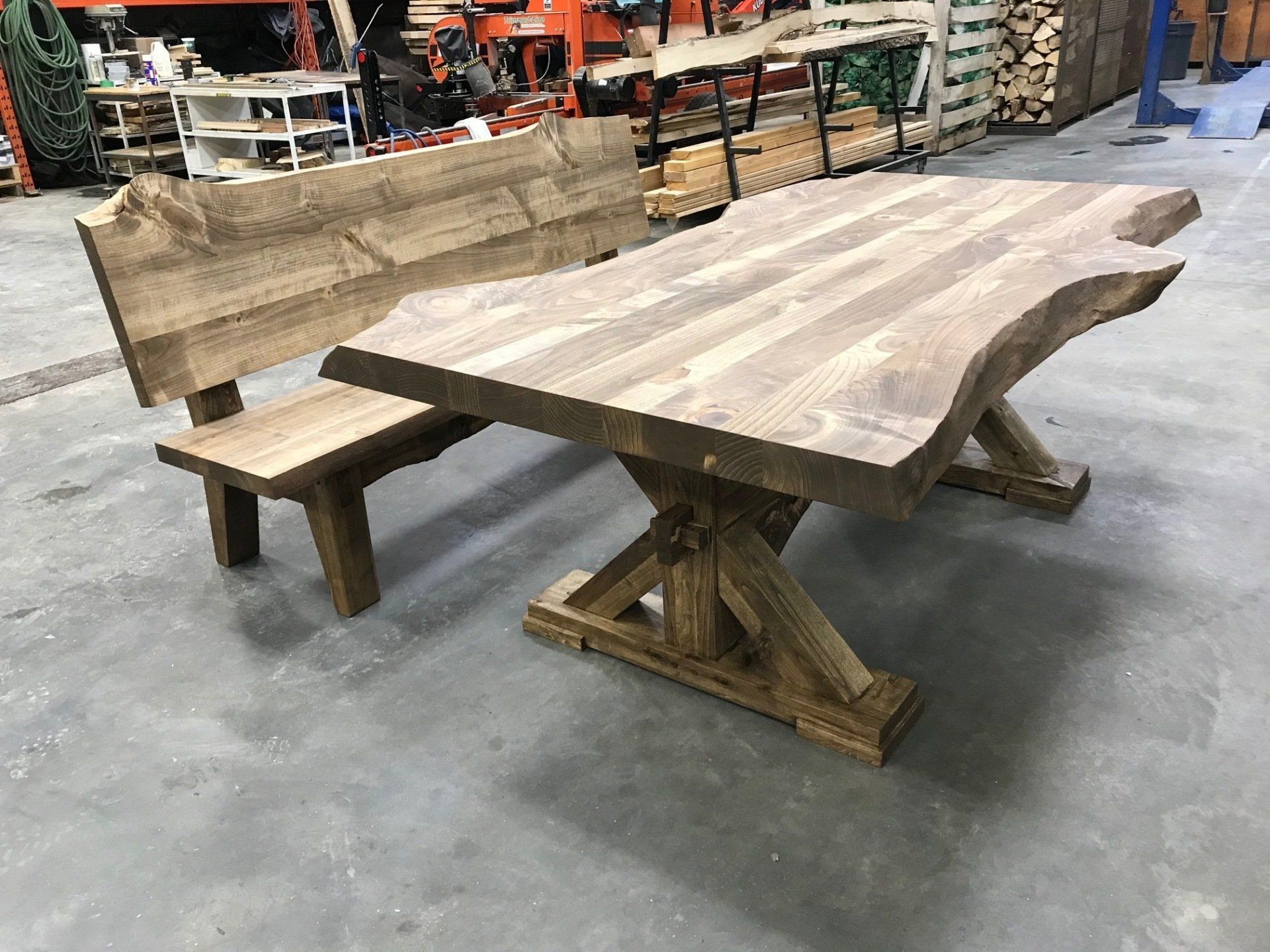 Rustic wooden dining table with bench in a workshop setting