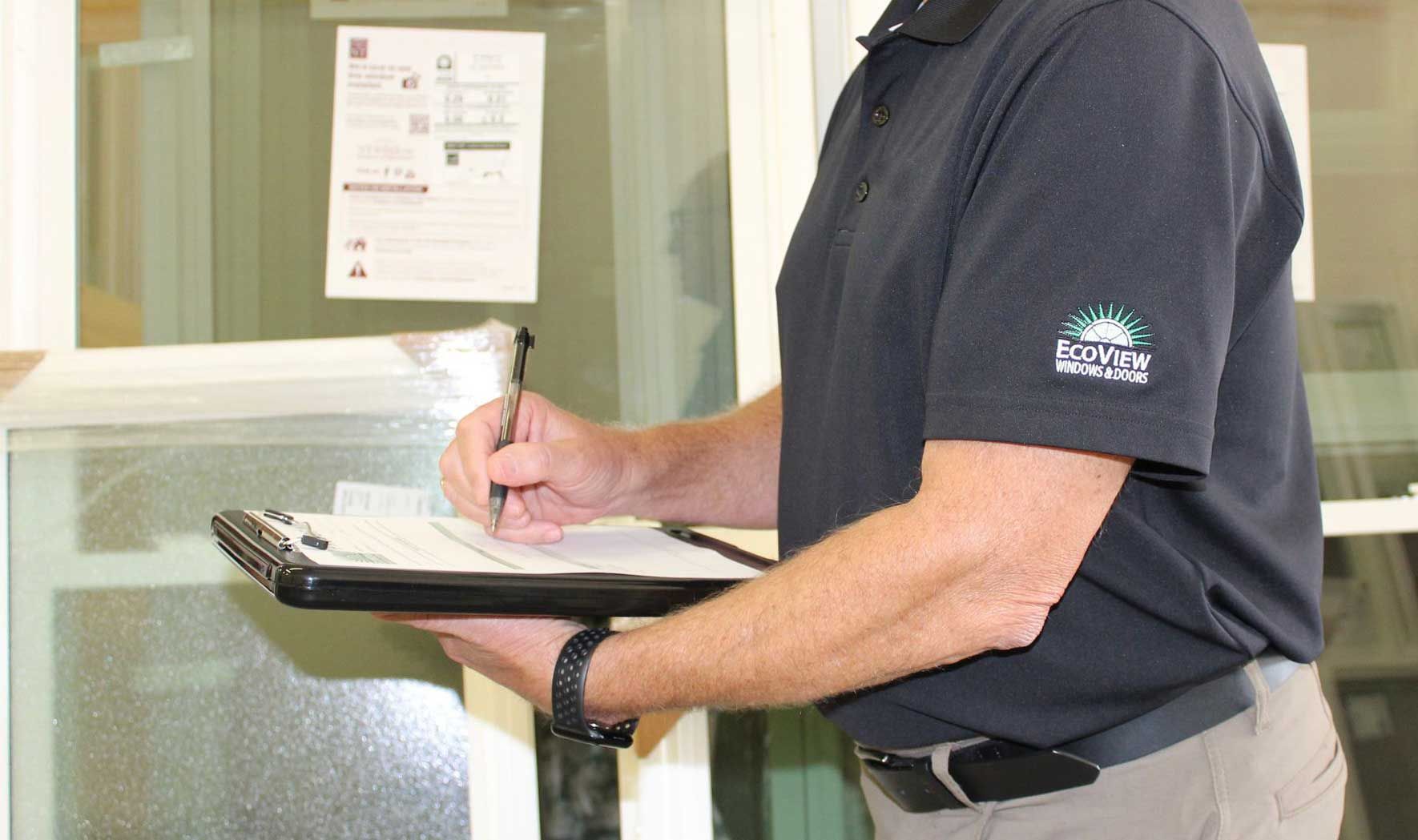 A man is holding a clipboard and writing on it.
