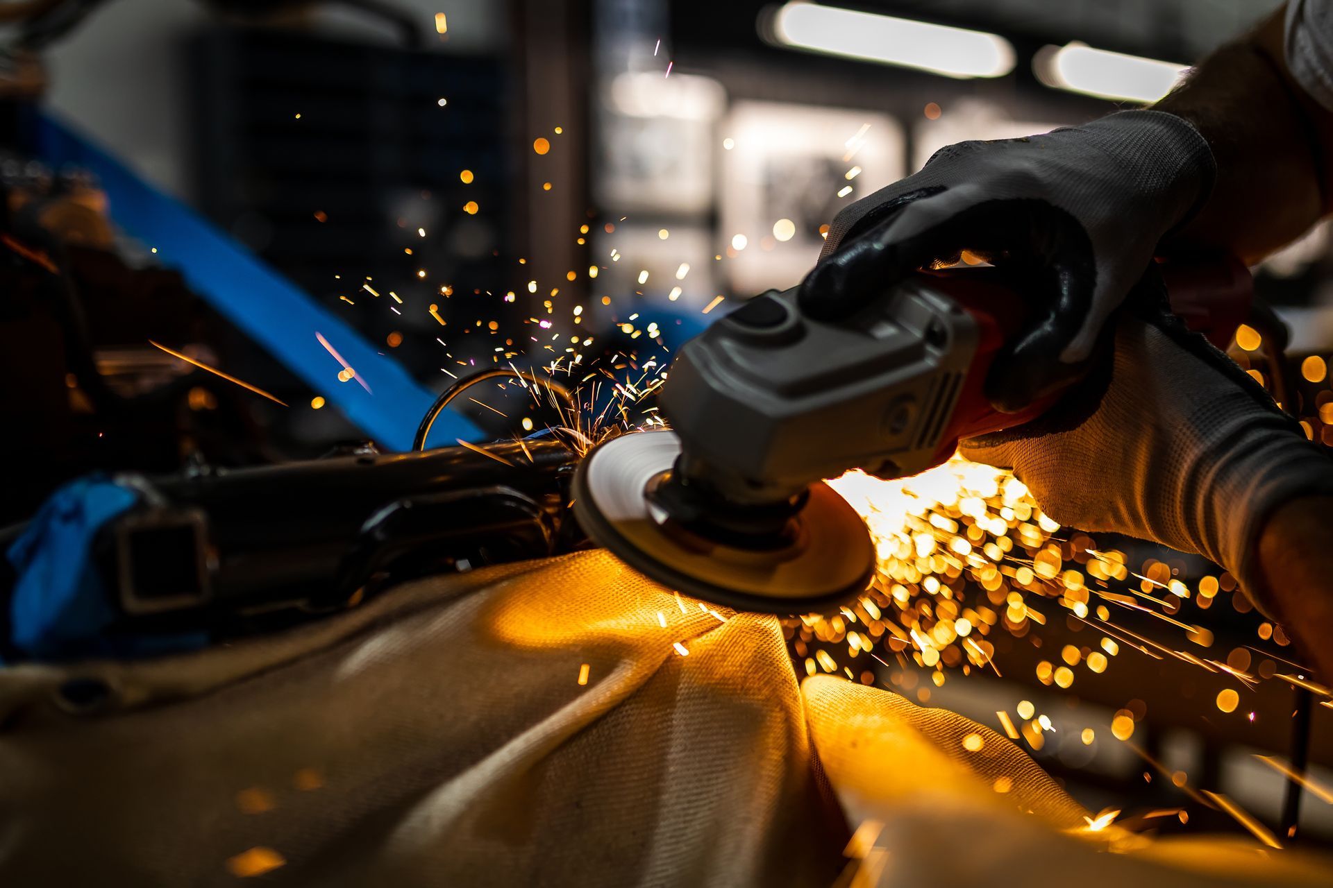 Person using a power grinder, creating sparks.
