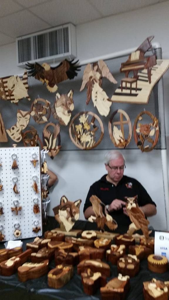 Bakery stall with assorted loaves and pastries, vendor behind the table, wooden holiday ornaments displayed above