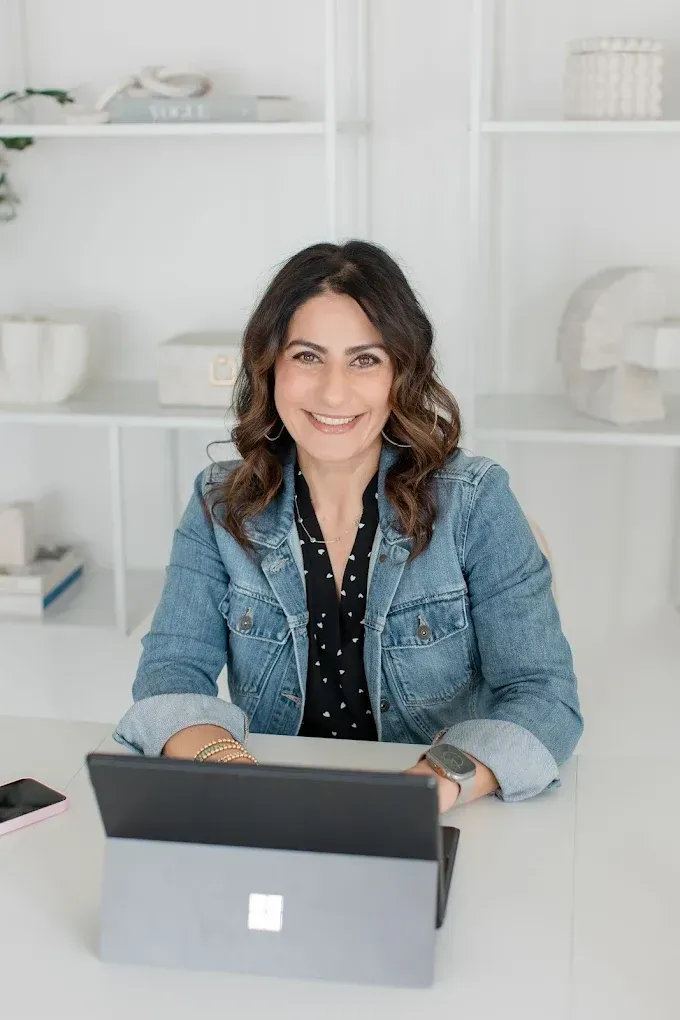 Mania Persekian, REALTOR, posing in a bright white interior.