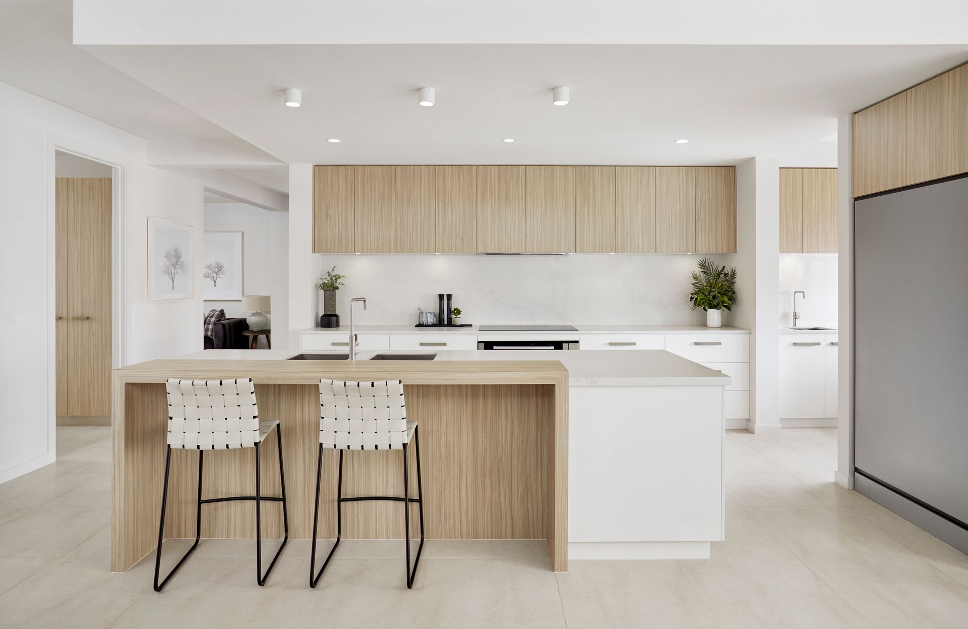 Open-concept kitchen with wood cabinetry, white countertops, and bar seating.