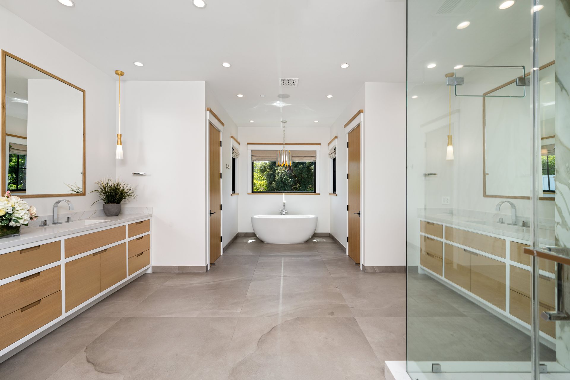 Spacious luxury home bathroom featuring dual vanities and modern finishes in a coastal home.