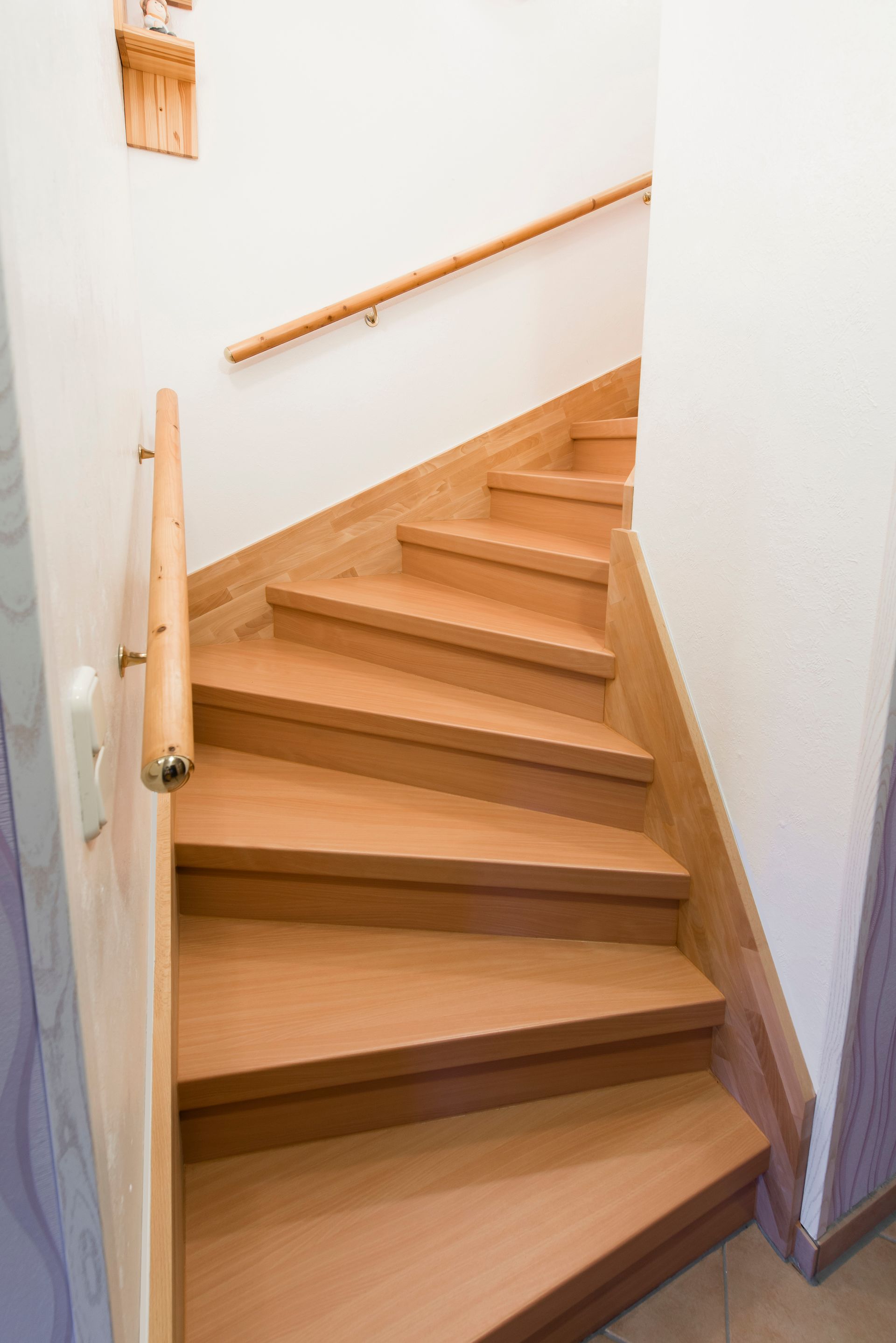 Holztreppe mit Handlauf in einem schmalen Flur