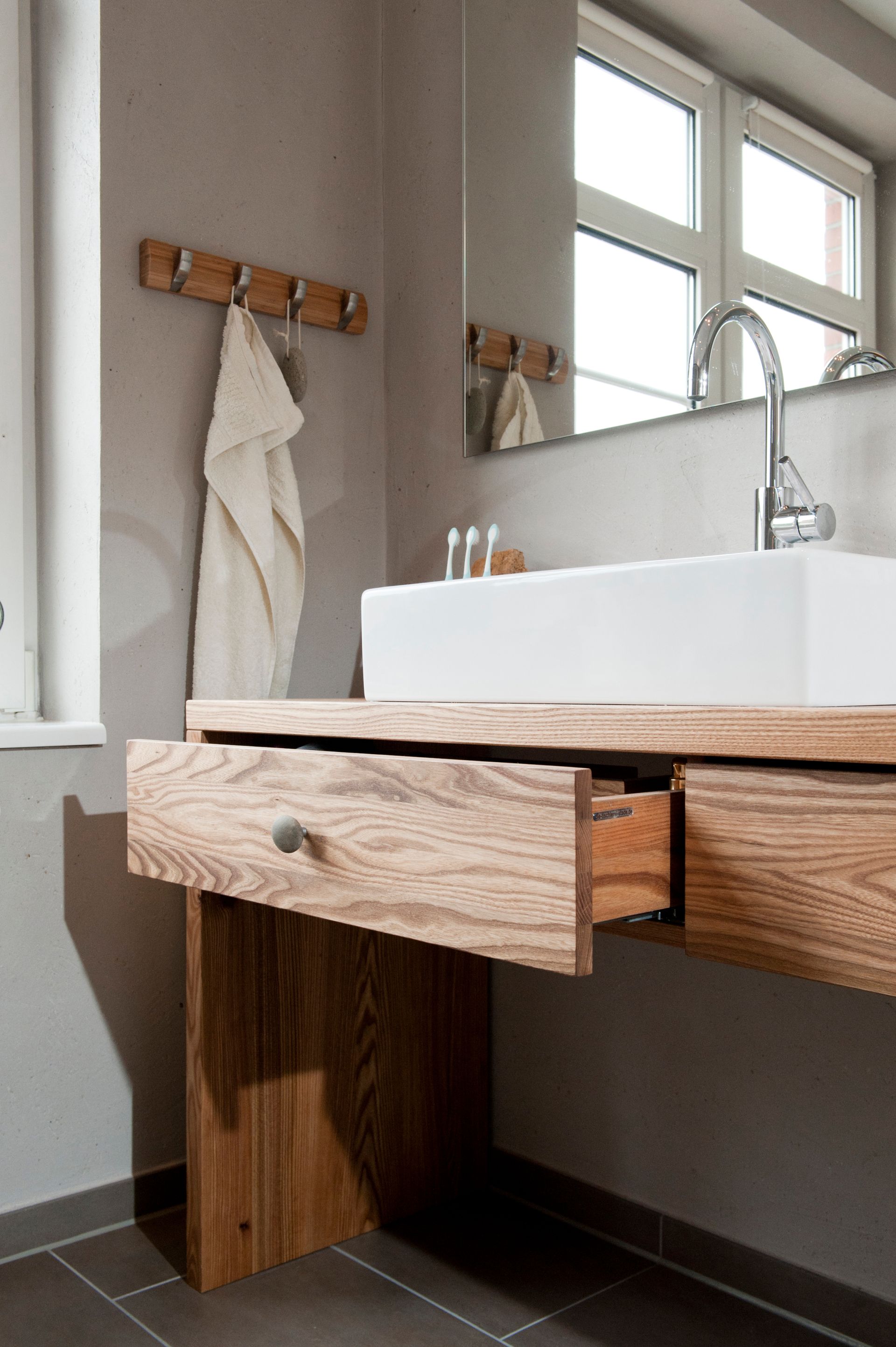 Moderner Badezimmerwaschtisch mit Holzschublade, weißem Waschbecken, Handtuchhalter und Fensterleuchte