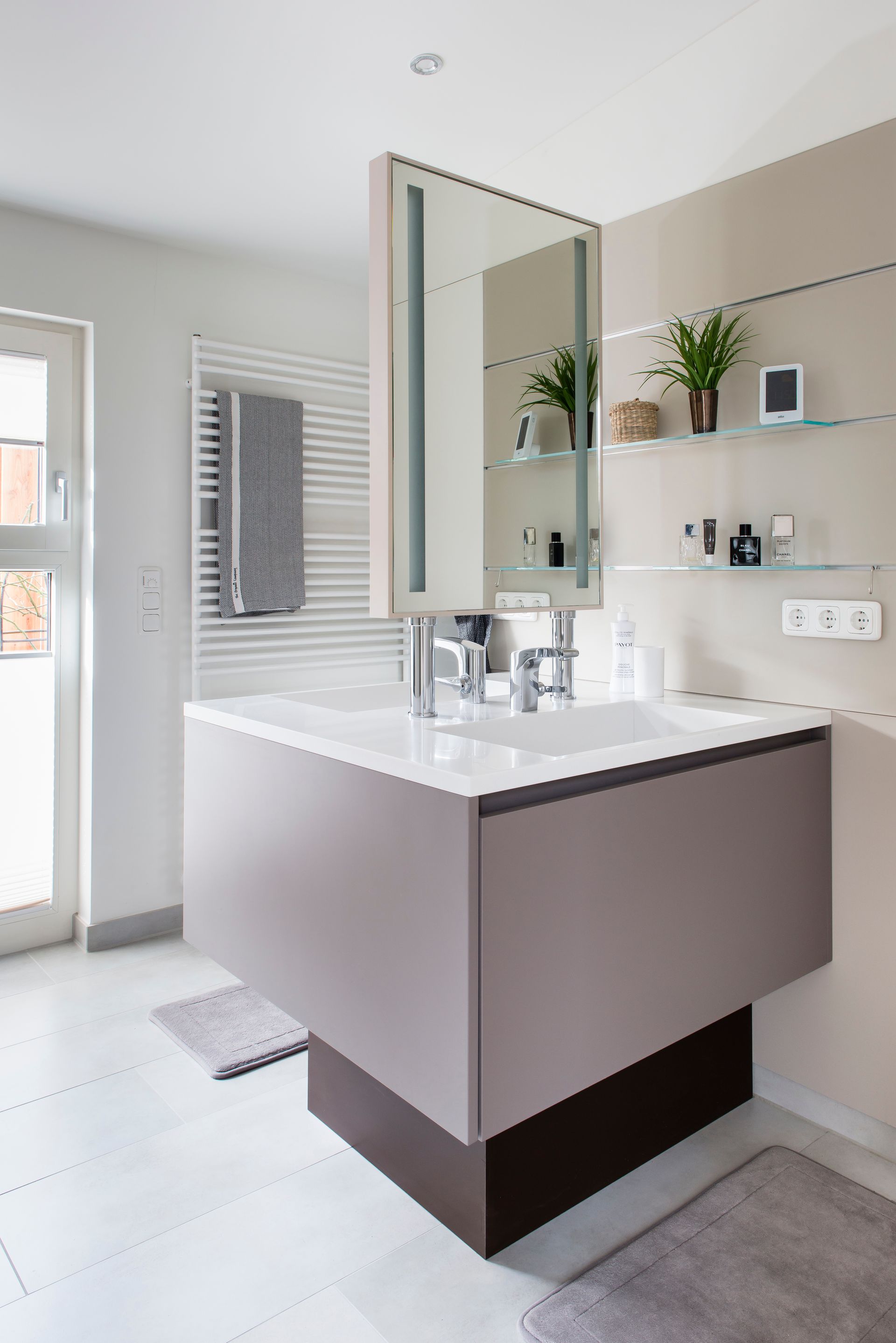 Moderner Badezimmerschrank mit Waschbecken, Spiegelschrank, Handtuchhalter und weißen Fliesenwänden