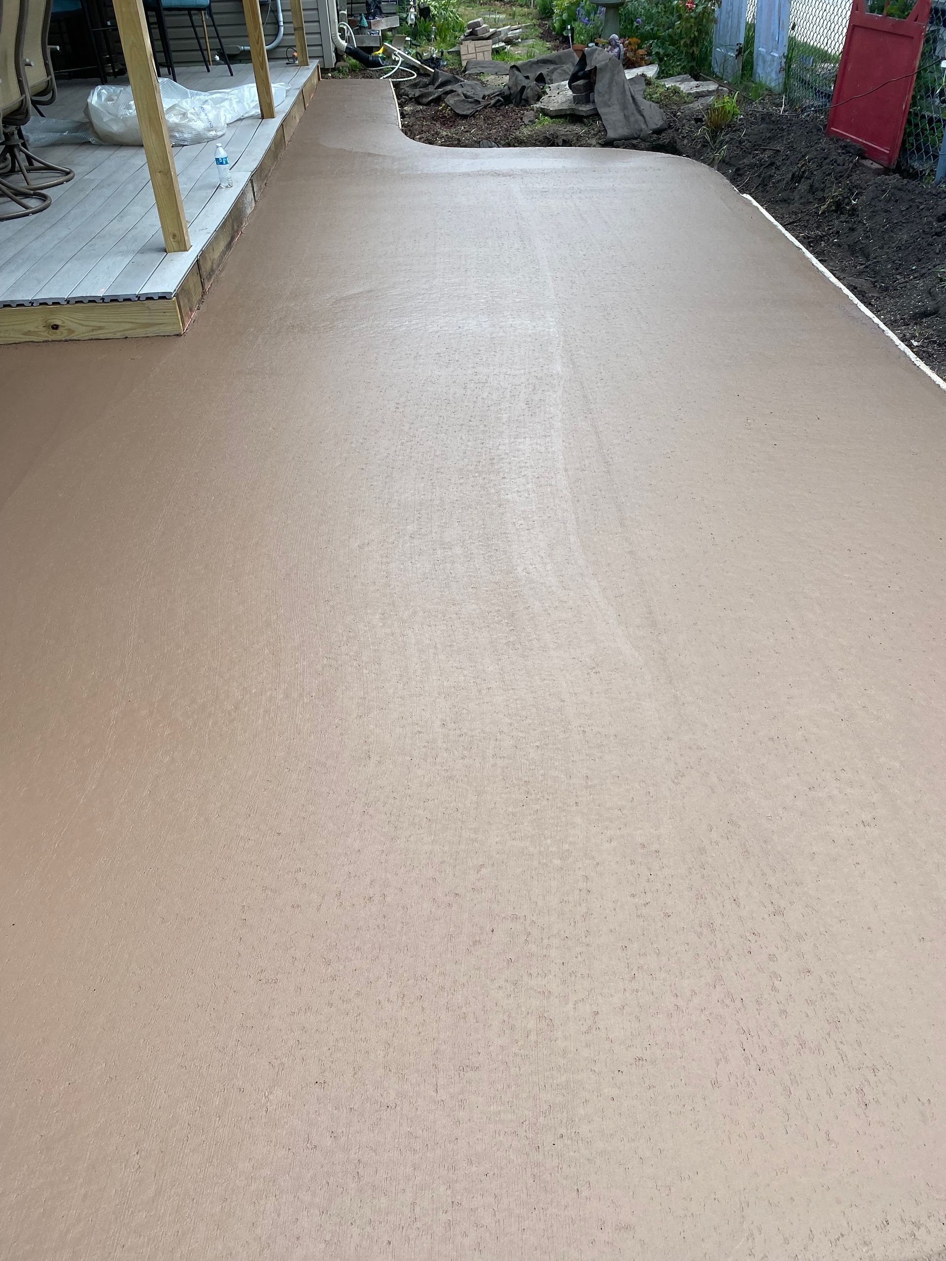 A concrete driveway is being built in a backyard.