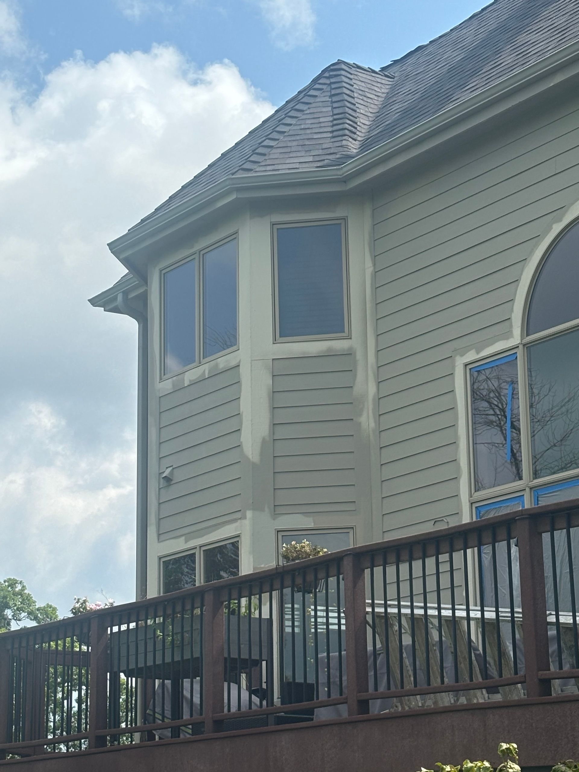 Close-up of new gutter installation around a bay window and multi-level roofline in Janesville, WI.