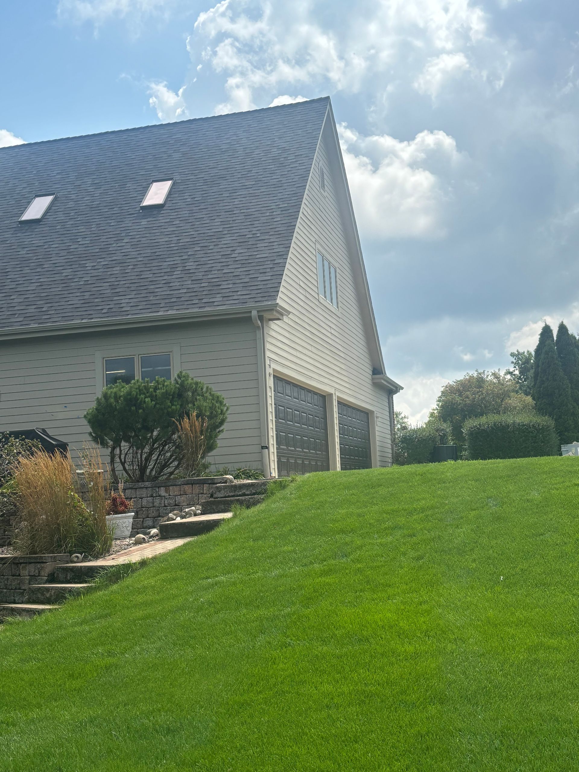 1. New gutter installation along a steep roofline and garage on a large Janesville, Wisconsin home.