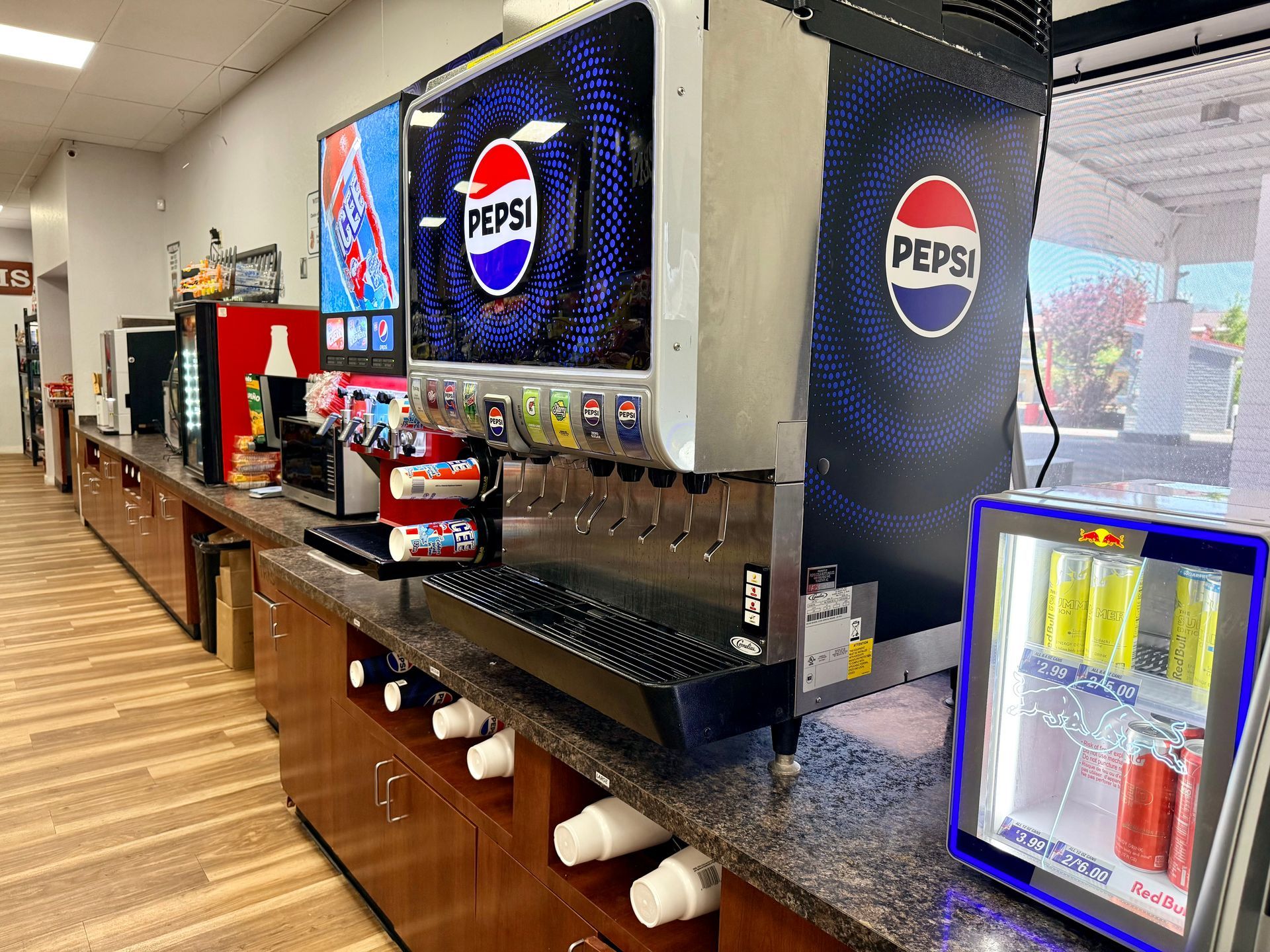 Shelves in a convenience store filled with various candy and snacks, a restroom sign is visible.