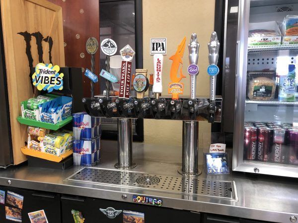 Beer taps in a store. Snacks, drinks, and a cooler are visible.