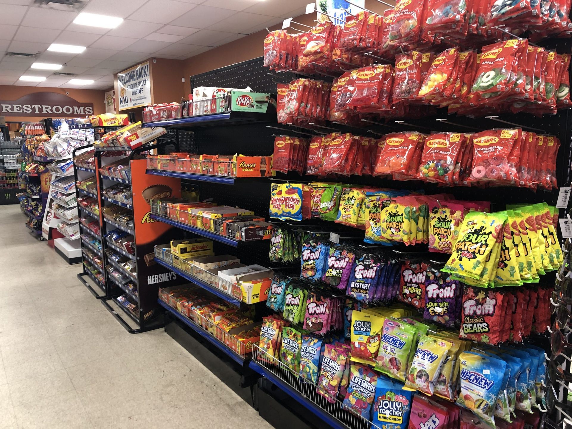 Candy aisle in a convenience store filled with various packaged sweets.