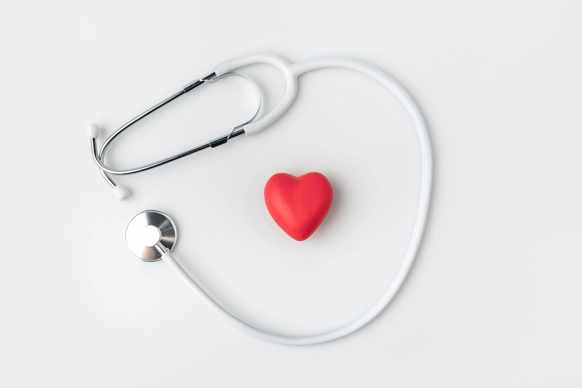 Stethoscope with red heart on white background