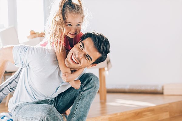 a man is carrying a little girl on his shoulders .