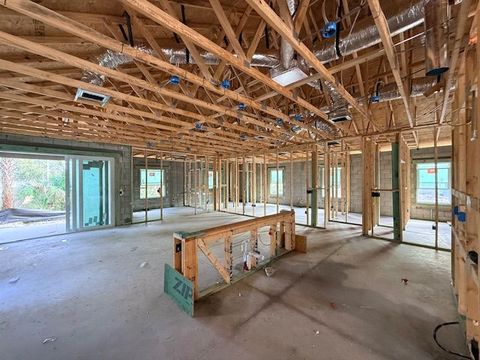 Interior of a house under construction with exposed wooden framing and unfinished walls and floor