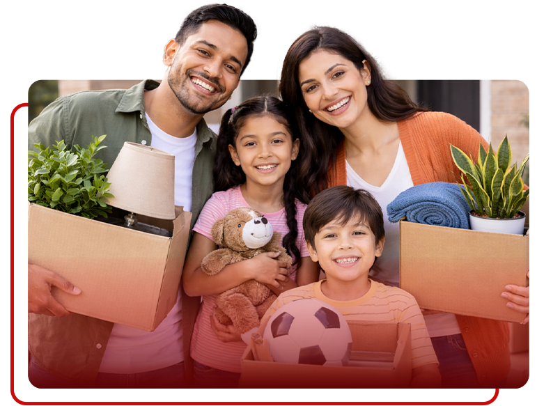 A smiling family holding cardboard boxes and personal items, representing moving into a new home.