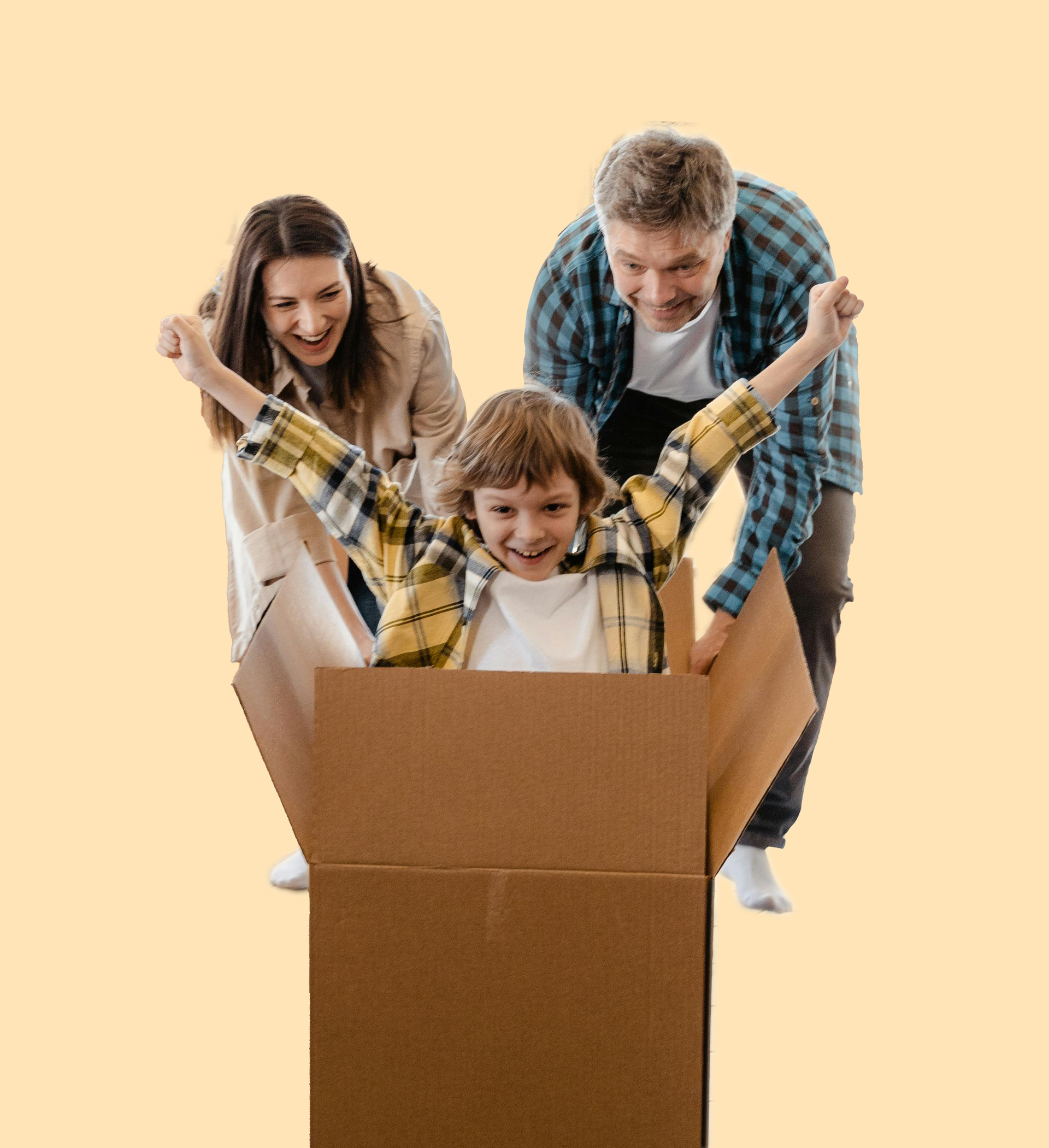 A child sits inside a cardboard box with arms raised, cheered on by two adults standing behind against a light background.