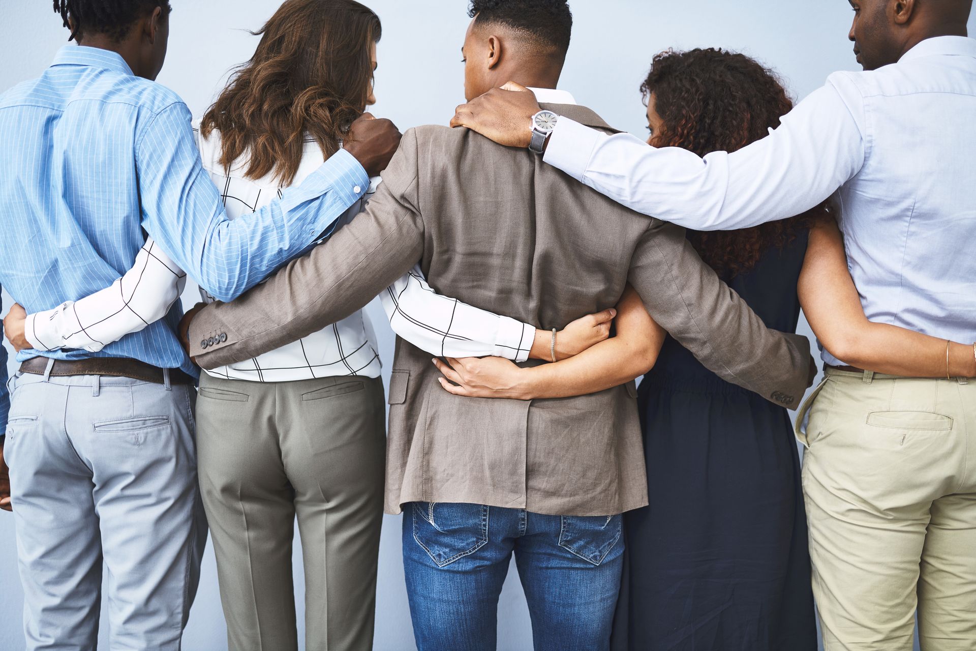 group photo of a team of managers hugging from behind