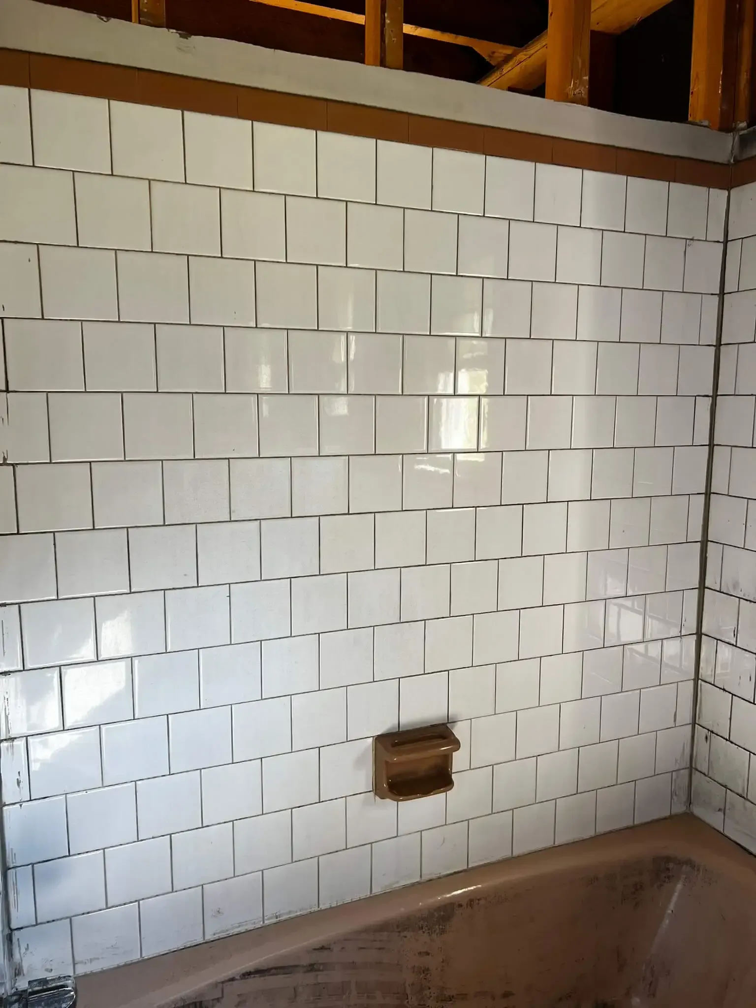 a bathroom tub area after fire remediation services with white tiles