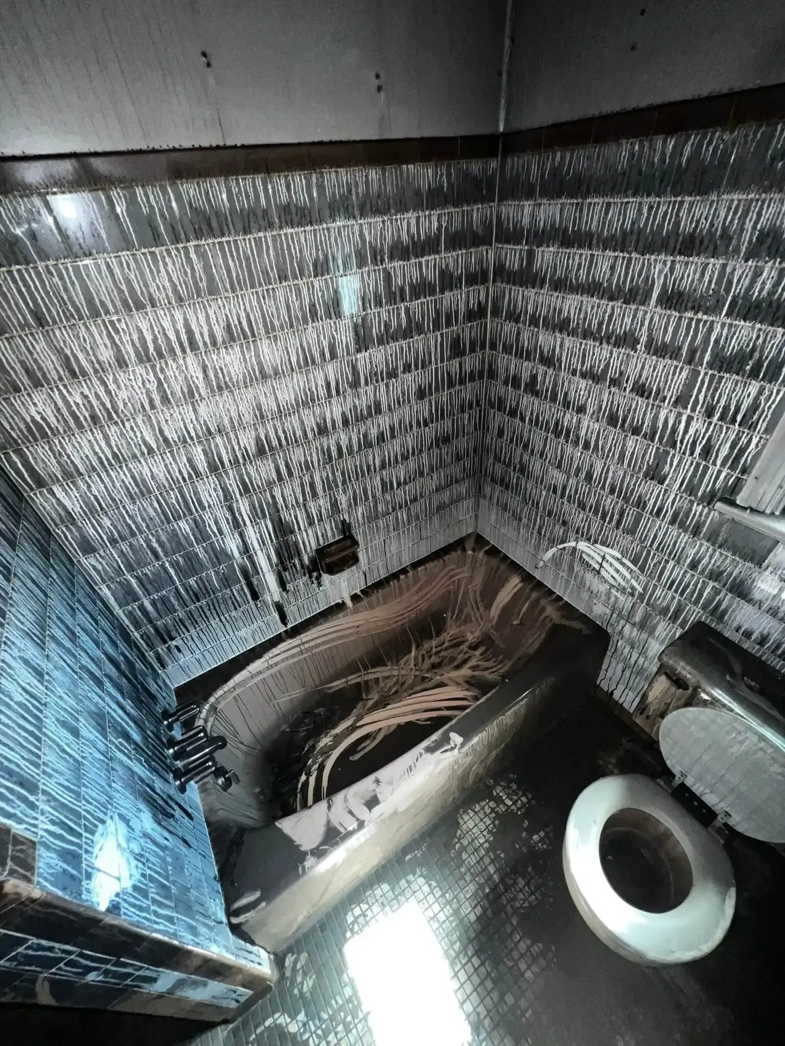 a bathroom with fire damage to
a bathtub , toilet , and shower .
