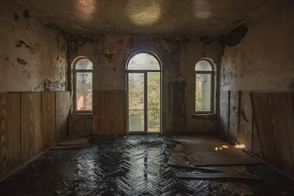 a room with a lot of windows and a
flooded floor in an abandoned building .