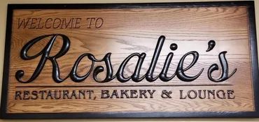 A wooden sign with a black frame reads