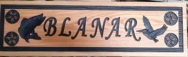 A rectangular wood sign with a dark border, reading