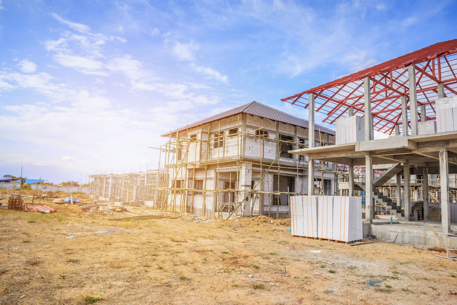 A couple of houses are being built in a field.