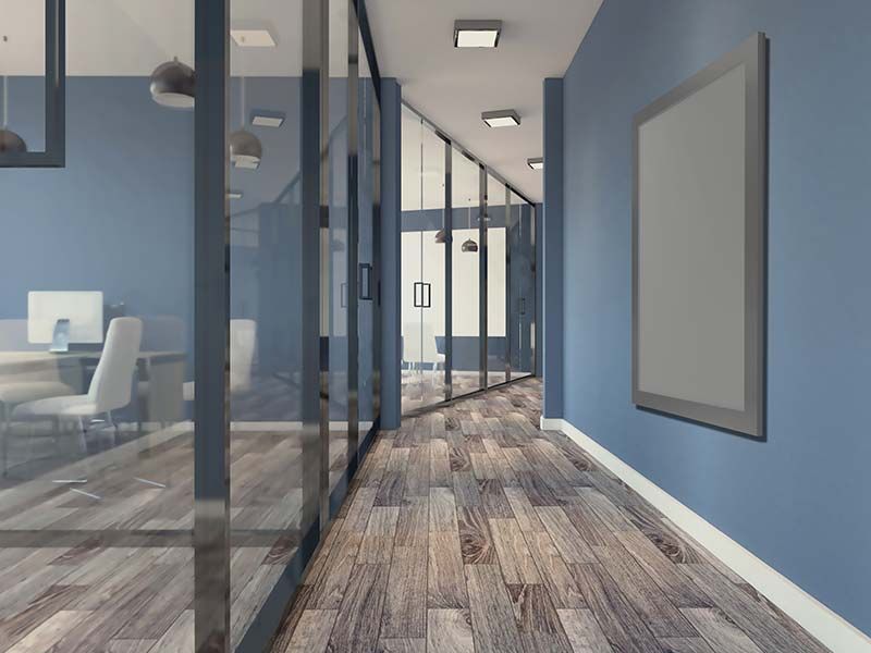 A hallway in an office with blue walls and wooden floors
