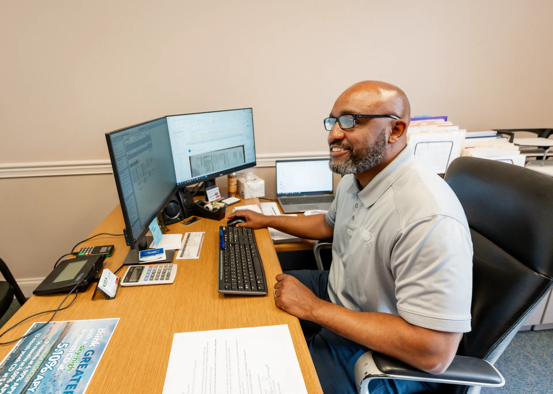 Man at desk working on computer; office setting.