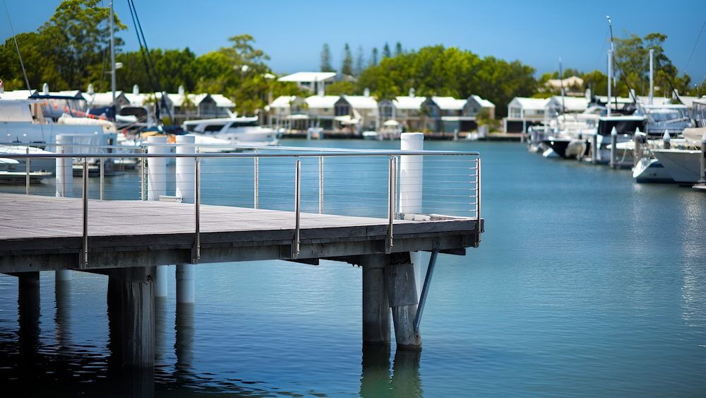A Dock With A Railing Overlooking A Body Of Water — Gold Coast Roof Repairs in Hope Island, QLD
