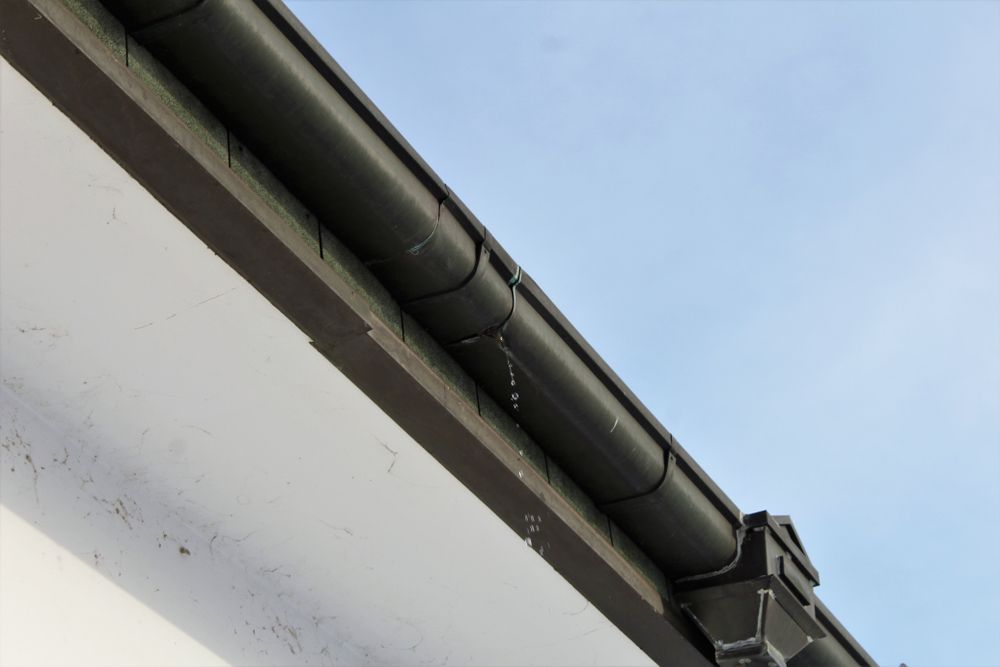 Black Rain Gutter Leaking Water Droplets