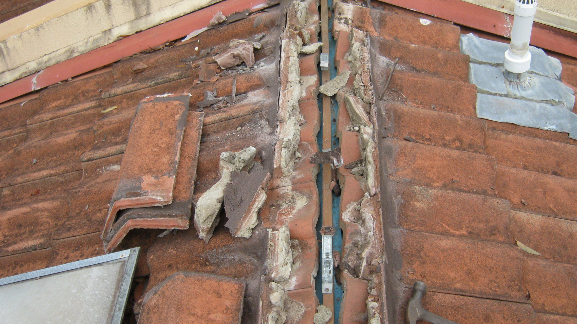 Damaged Roof Flashing Between Red Tiles