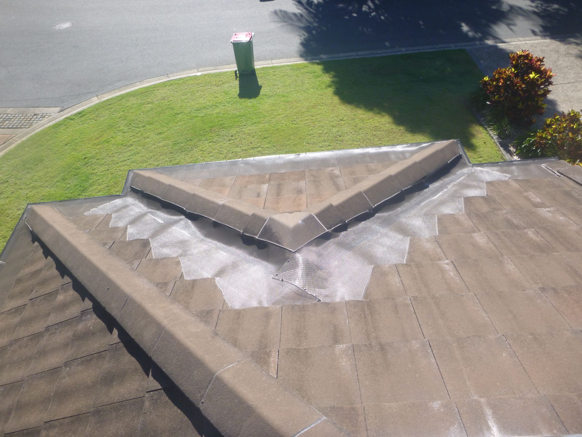 A Person Is Cleaning A Gutter With A High Pressure Washer — Gold Coast Roof Repairs in Hope Island, QLD