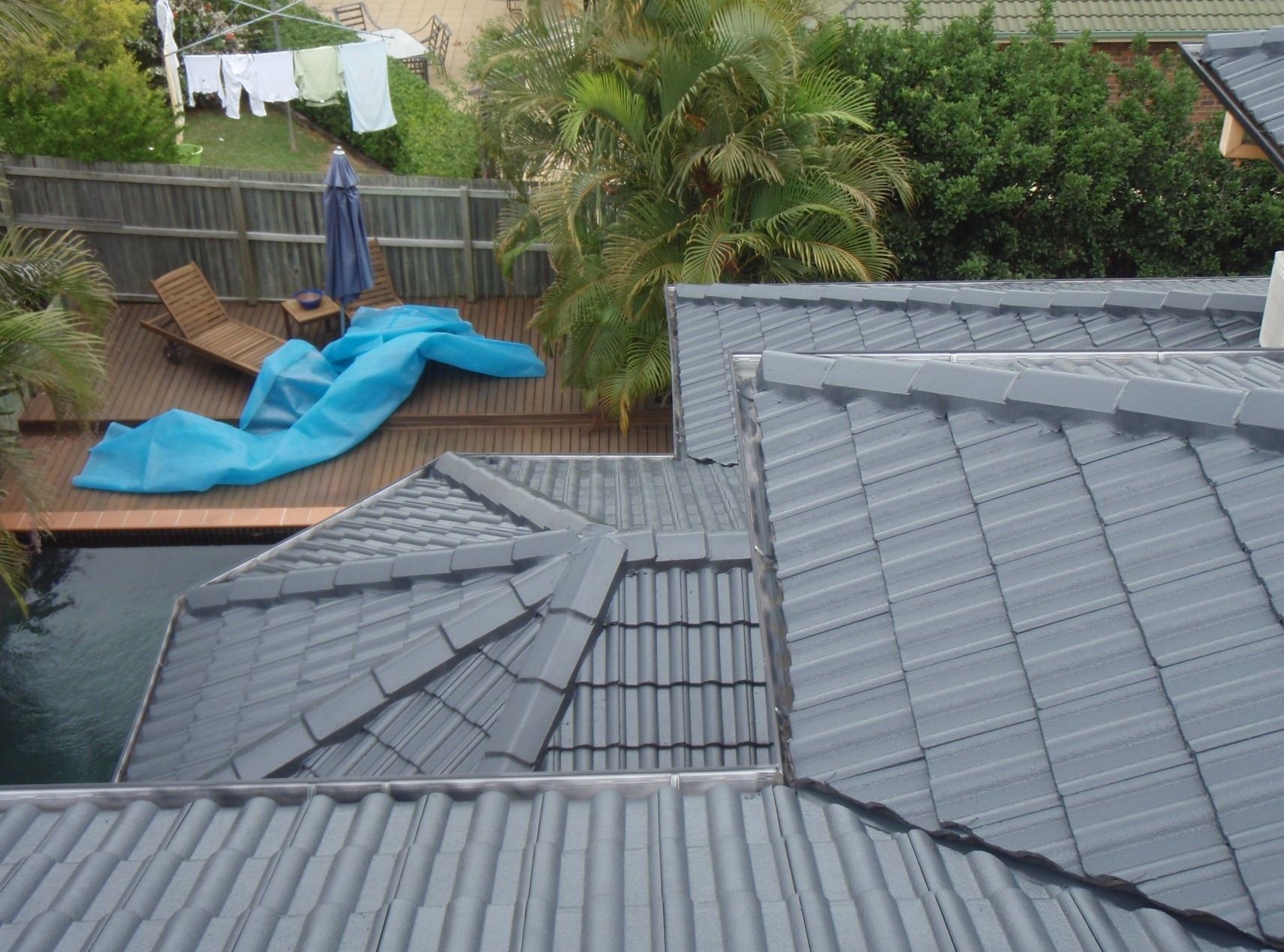 The roof of a house has a blue tarp on it