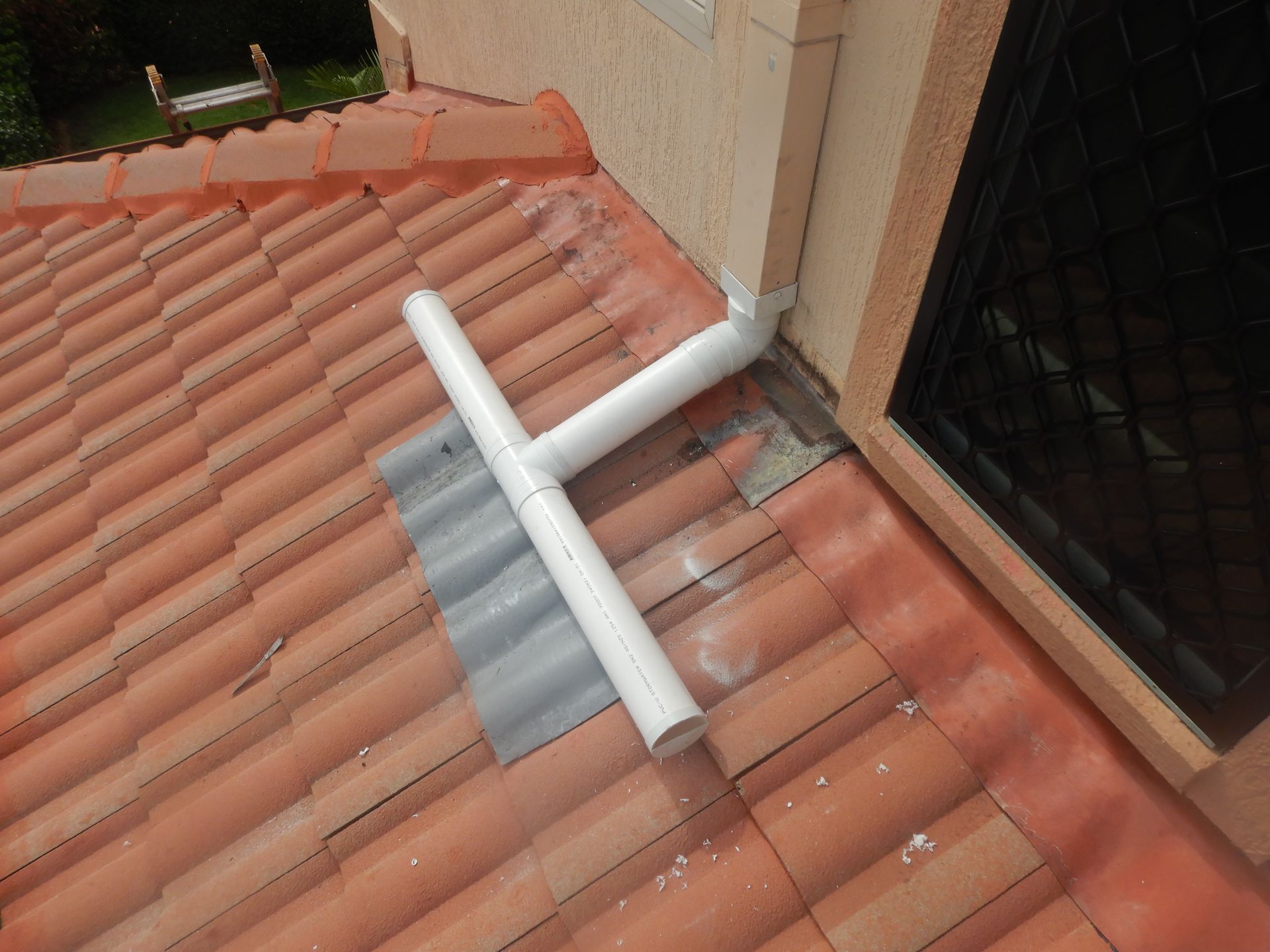 A White Spreader Downpipe Placed On A Roof — Gold Coast Roof Repairs in Mudgeeraba, QLD