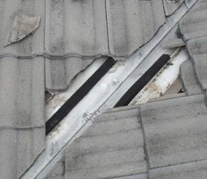 Installing Valley Seal On A Grey Tiled Roof — Gold Coast Roof Repairs in Mudgeeraba, QLD